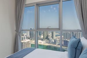 a bedroom with a large window with a view of the city at Urban Chic - Radiant in Abu Dhabi