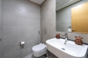 a bathroom with a sink and a toilet and a mirror at Urban Chic - Radiant in Abu Dhabi +74 photos