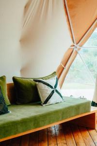 a green couch with pillows in a room with a window at Rafiki Retreat in Arusha