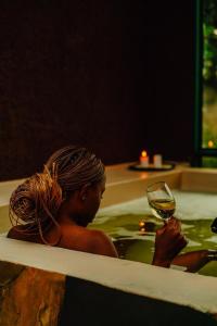 a woman sitting in a bath tub holding a glass of wine at Rafiki Retreat in Arusha