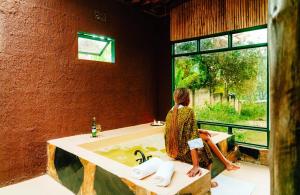 a woman standing in a bathroom with a sink at Rafiki Retreat in Arusha