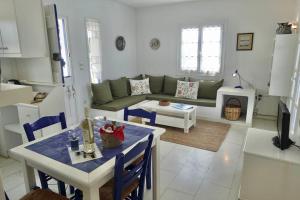 a living room with a couch and a table at Villa G - Kamari Village in Kastraki