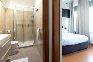 a bathroom with a shower and a toilet and a bed at Pescara Centro sul Mare in Pescara