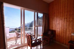 a room with a balcony with a table and chairs at Blue Pine Resort in Lansdowne