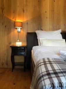 a bedroom with a bed and a table with a lamp at Bergromantik Ferienwohnung Nesterl mit eigener Sauna und Bergblick in Marktschellenberg