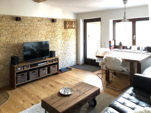a living room with a television and a table at Bergromantik Ferienwohnung Nesterl mit eigener Sauna und Bergblick in Marktschellenberg