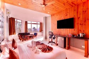 a living room with a bed and a flat screen tv at Blue Pine Resort in Lansdowne