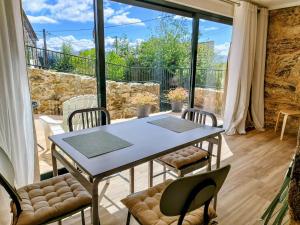 a table and chairs in a room with a large window at Alojamientos as moras arans in La Cañiza