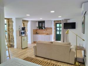 a living room with a couch and a kitchen at Alojamientos as moras arans in La Cañiza