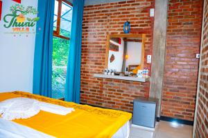 a room with a bed and a brick wall at Thuru Airport Apartment in Seeduwa +8 photos