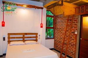 a bedroom with a bed and a brick wall at Thuru Airport Apartment in Seeduwa