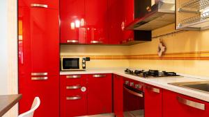 a red kitchen with red cabinets and a microwave at I Portici - Cernobbio in Cernobbio