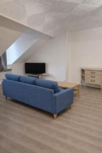 a blue couch in a living room with a tv at Functional and convenient apartment avec wifi in La Machine