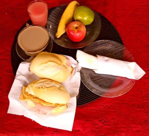 a plate with a sandwich and fruit on a table at Pousada O Povorello - a 1 minuto a pé da Praia Grande da Baía do Sol in Mosqueiro +55 photos