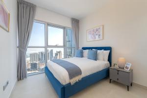 a bedroom with a blue bed and a large window at Urban Chic - Radiant in Abu Dhabi