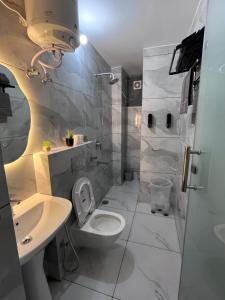 a white bathroom with a toilet and a sink at Solskyhaus in Rishīkesh +22 photos