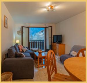 a living room with a couch and a table at L'appartement des Cimes I Doussard in Doussard