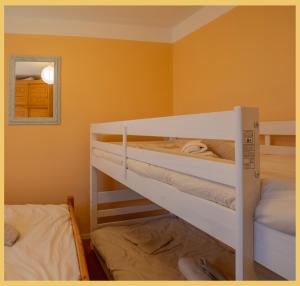 two bunk beds in a room with orange walls at L'appartement des Cimes I Doussard in Doussard