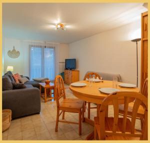 a living room with a table and a couch at L'appartement des Cimes I Doussard in Doussard