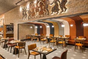 a restaurant with tables and chairs and a brick wall at Canopy By Hilton Izmir Bomonti in İzmir +53 photos