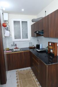 a kitchen with wooden cabinets and a black counter top at Solskyhaus in Rishīkesh