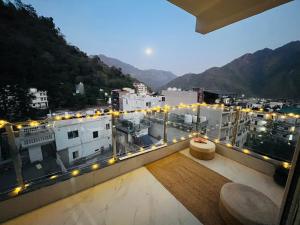 a balcony with a view of a city with lights at Solskyhaus in Rishīkesh