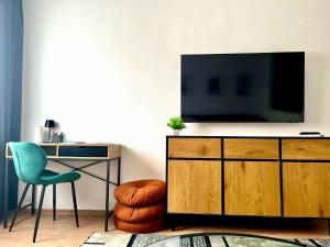 a living room with a television on a dresser with a desk at VestaLak in Tata