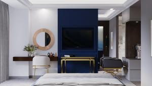 a bedroom with a blue accent wall and a tv at Three Corners Hotel in Skopje