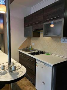 a kitchen with a sink and a stove top oven at Apartament Piatra Neamț Centru in Piatra Neamţ
