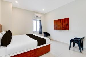 a bedroom with a bed and two chairs in it at Super Hotel O RB Classic Inn in Kottapalli