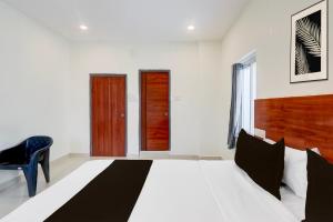 a bedroom with a large bed and a blue chair at Super Hotel O RB Classic Inn in Kottapalli