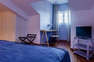 a bedroom with a bed and a desk with a television at Vale De Ferreiros in Abrantes