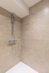 a shower with a shower head in a bathroom at Zest Vendome - Saxe Gambetta in Lyon