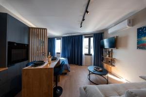 a hotel room with a bed and a living room at Gaia Apartments in Mytilene