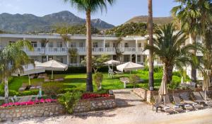 a resort with palm trees and chairs and mountains at Begovina in Marmaris