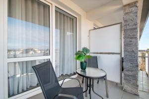 a balcony with a table and chairs and a window at RentPlanet - Welle Resort in Grzybowo +6 photos