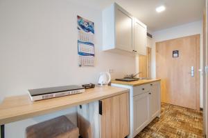 a small kitchen with a counter top and a sink at RentPlanet - Welle Resort in Grzybowo