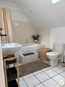 a bathroom with a tub and a toilet and a sink at Appartement Maisonnette pour 4 personnes in La Ferté-Vidame +4 photos