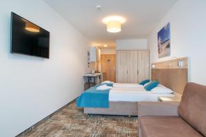 a hotel room with a bed and a couch at RentPlanet - Welle Resort in Grzybowo