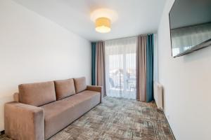 a living room with a couch and a flat screen tv at RentPlanet - Welle Resort in Grzybowo