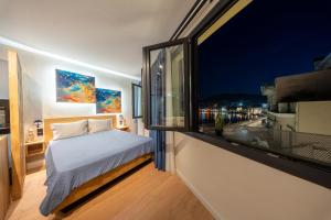a bedroom with a bed and a large window at Gaia Apartments in Mytilene