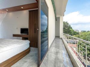 a bedroom with a balcony with a bed and a television at Phố Cổ Legend Hotel in Phúc Lộc