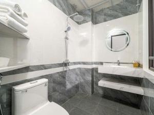 a bathroom with a toilet and a sink and a mirror at Phố Cổ Legend Hotel in Phúc Lộc