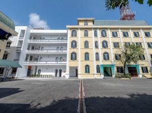 a large yellow building in front of a building at Phố Cổ Legend Hotel in Phúc Lộc +12 photos