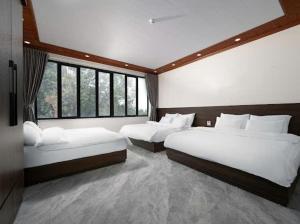 a bedroom with two beds and a large window at Phố Cổ Legend Hotel in Phúc Lộc