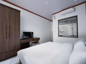 a bedroom with a bed and a desk and a window at Phố Cổ Legend Hotel in Phúc Lộc