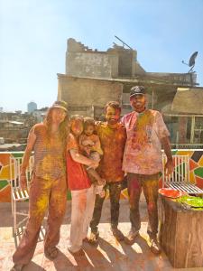 a group of people covered in paint posing for a picture at The Pink Nest - Backpackers Abode in Jaipur