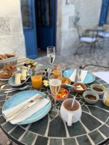 a table with plates of food and glasses of wine at LE petit CHABO in Saint-Maigrin