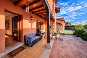 a patio with a couch and chairs on a house at Playa de La Franca, jardín y WiFi - Casa Freya in La Franca