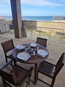 a wooden table with plates and cups on a balcony at Rook View in Buckie